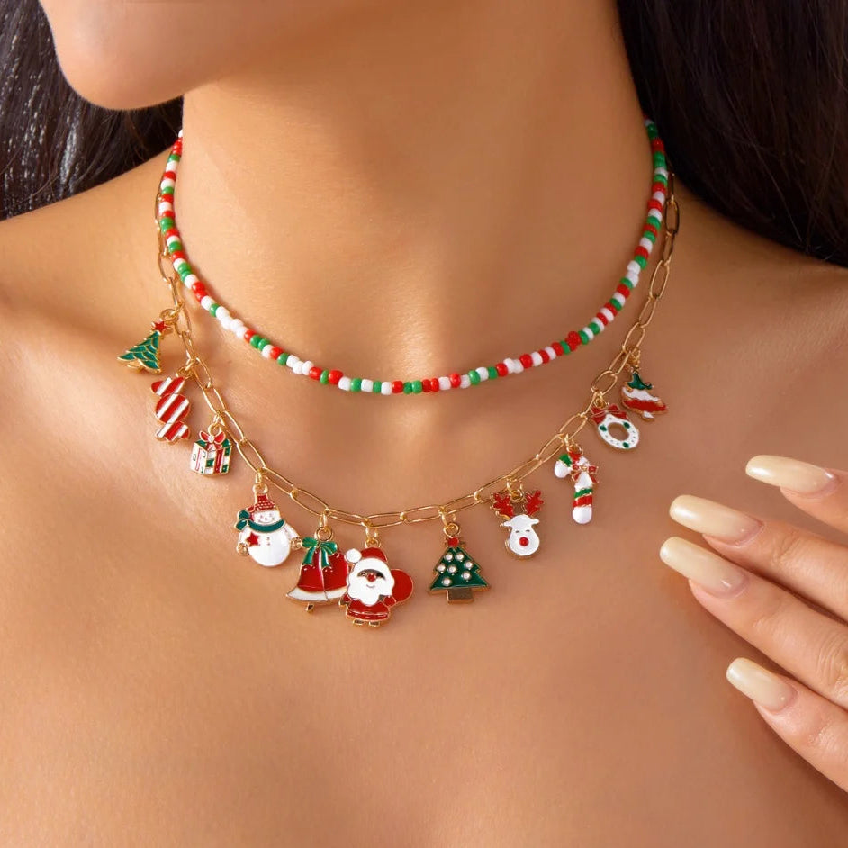 Christmas-themed necklace with Santa Claus and reindeer charms on a model wearing a red top.