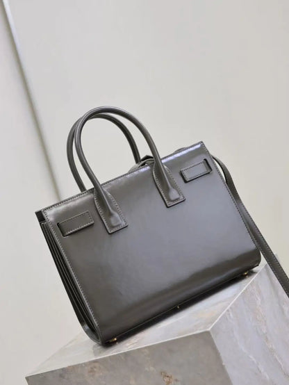 Black handbag on a light gray surface with a neutral background