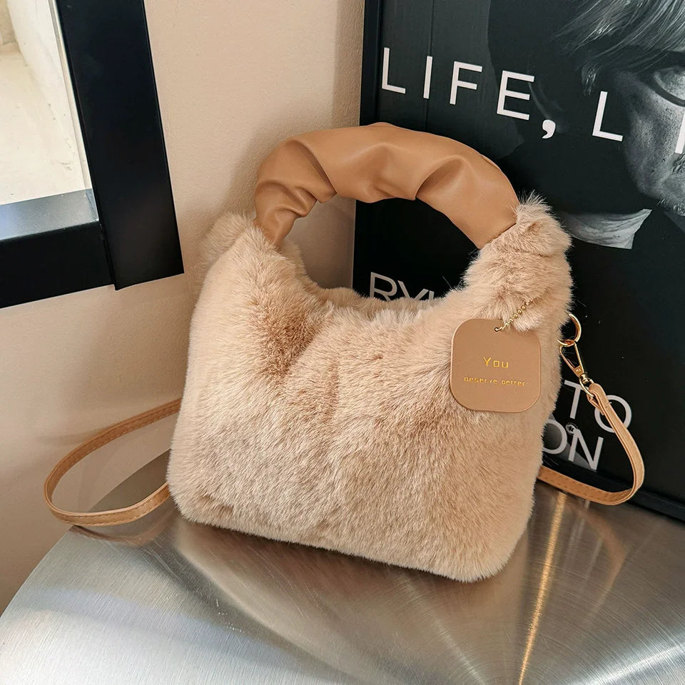 Beige fluffy handbag with a tag on a reflective surface