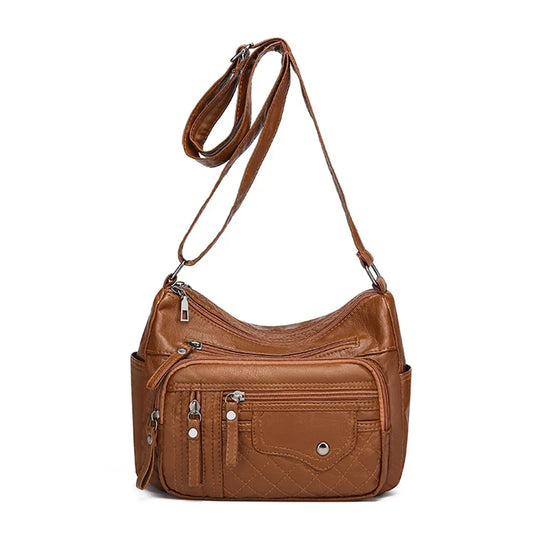 Brown leather handbag with multiple pockets and a strap on a white background