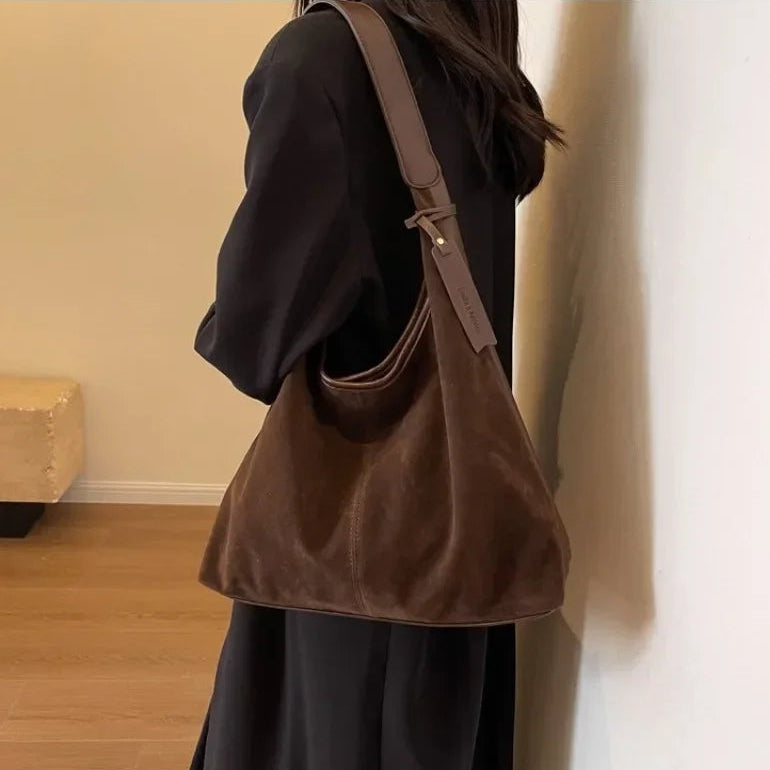 Person wearing a brown shoulder bag indoors