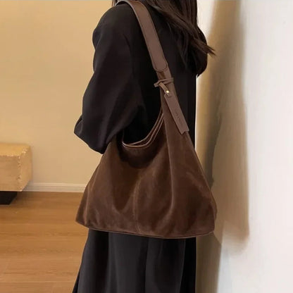 Person wearing a brown shoulder bag indoors