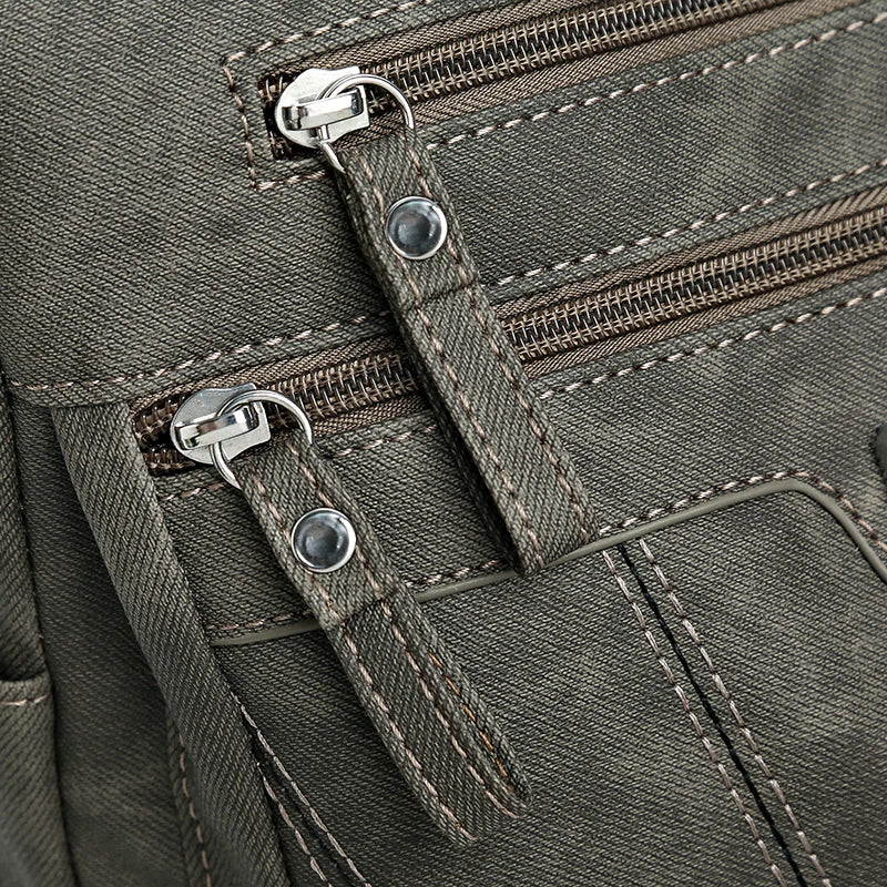 Close-up of a green backpack with zippers and stitching details
