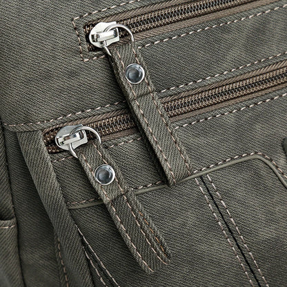 Close-up of a green backpack with zippers and stitching details