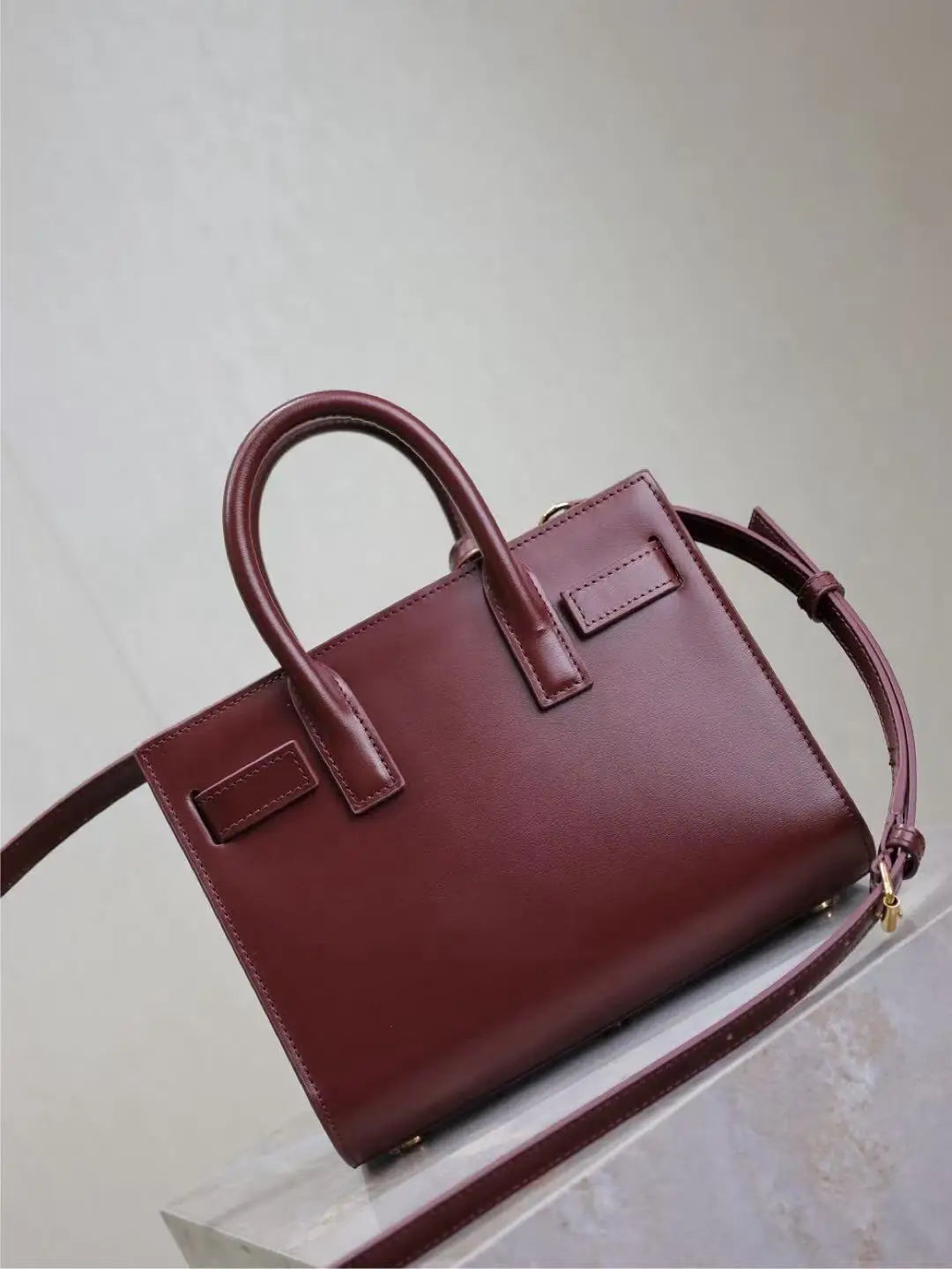 Maroon handbag on a light gray background