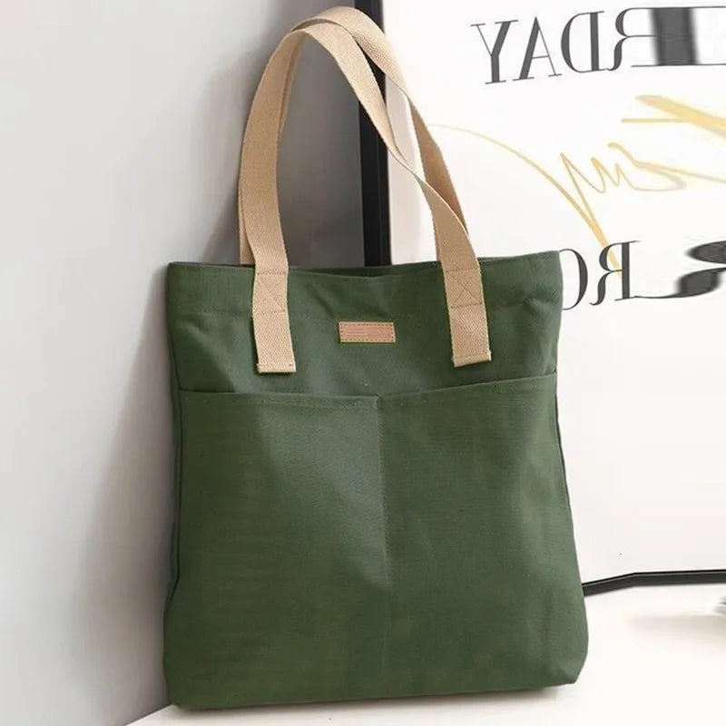 Green tote bag with beige handles on a white surface